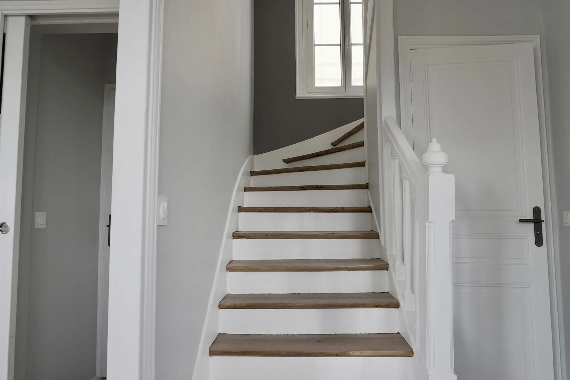 Escalier rénové, marches en bois et rampe blanche